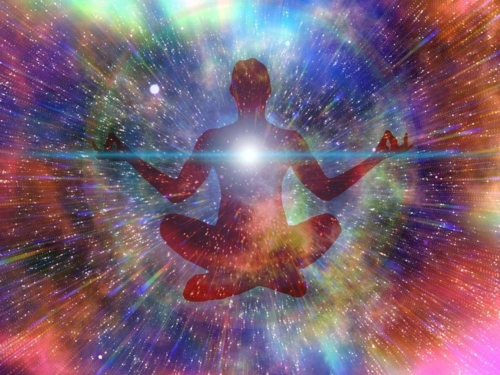 Person meditating in a colorful universe