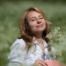 Woman holding flowers while standing in a grassy meadow