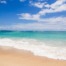 Turquoise ocean water with waves and a sandy beach