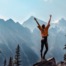 Woman, with arms outstretched, on top of a mountain