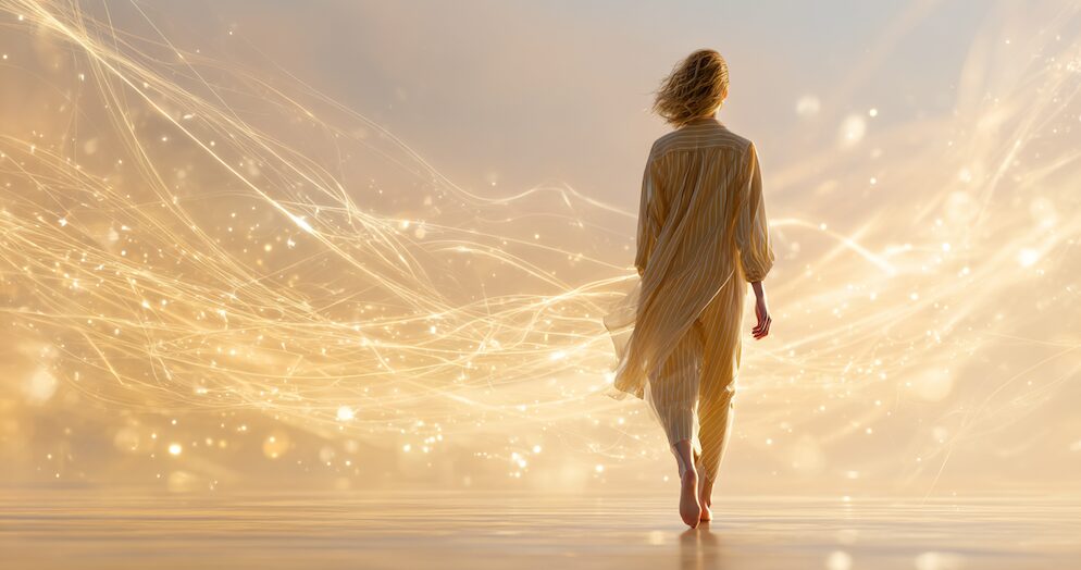 Woman walking on a beach with strands of white energy trailing off of her